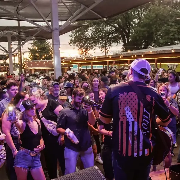 Jordan Beem playing to a crowded outdoor patio from the stage